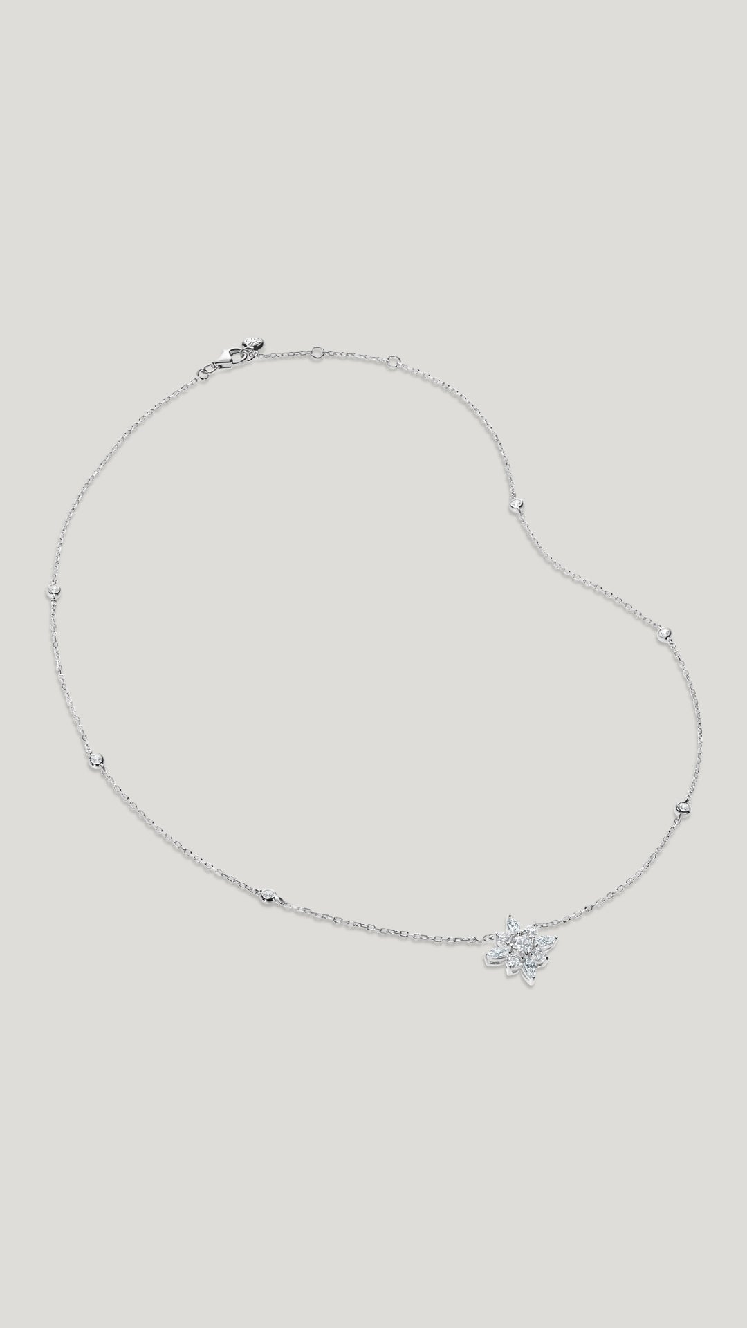  This necklace features a delicate chain embellished with Round cut stones in bezel setting. A cluster of Round and Marquise cut stones resembles a flower with a hint of vintage romance. 