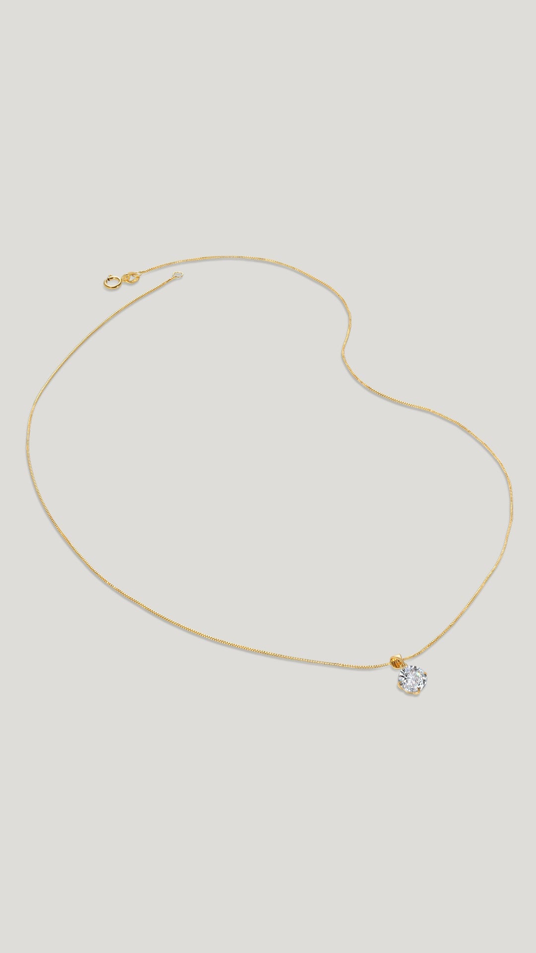 A classic four-prong solitaire pendant necklace set in 9k solid Yellow Gold with a glittering round brilliant-cut stone.