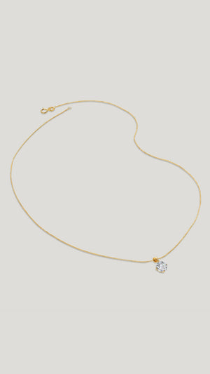 A classic four-prong solitaire pendant necklace set in 9k solid Yellow Gold with a glittering round brilliant-cut stone.