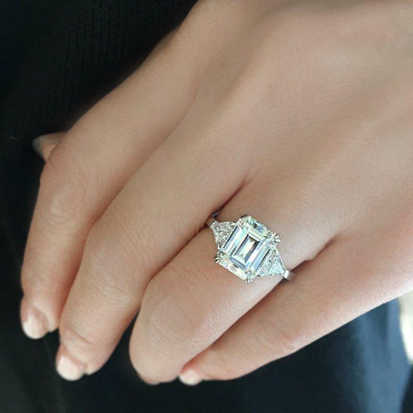 9K White Gold Trilogy Ring - 3ct Emerald Centre Stone, 2 Trillion Side Stones